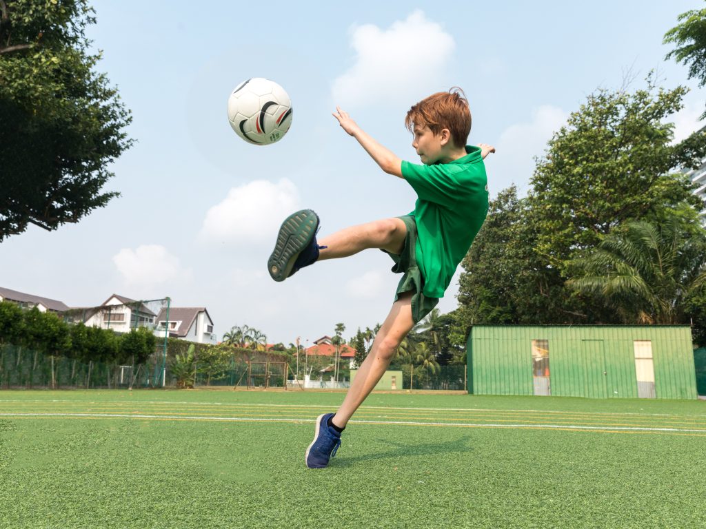 Student kicking soccer