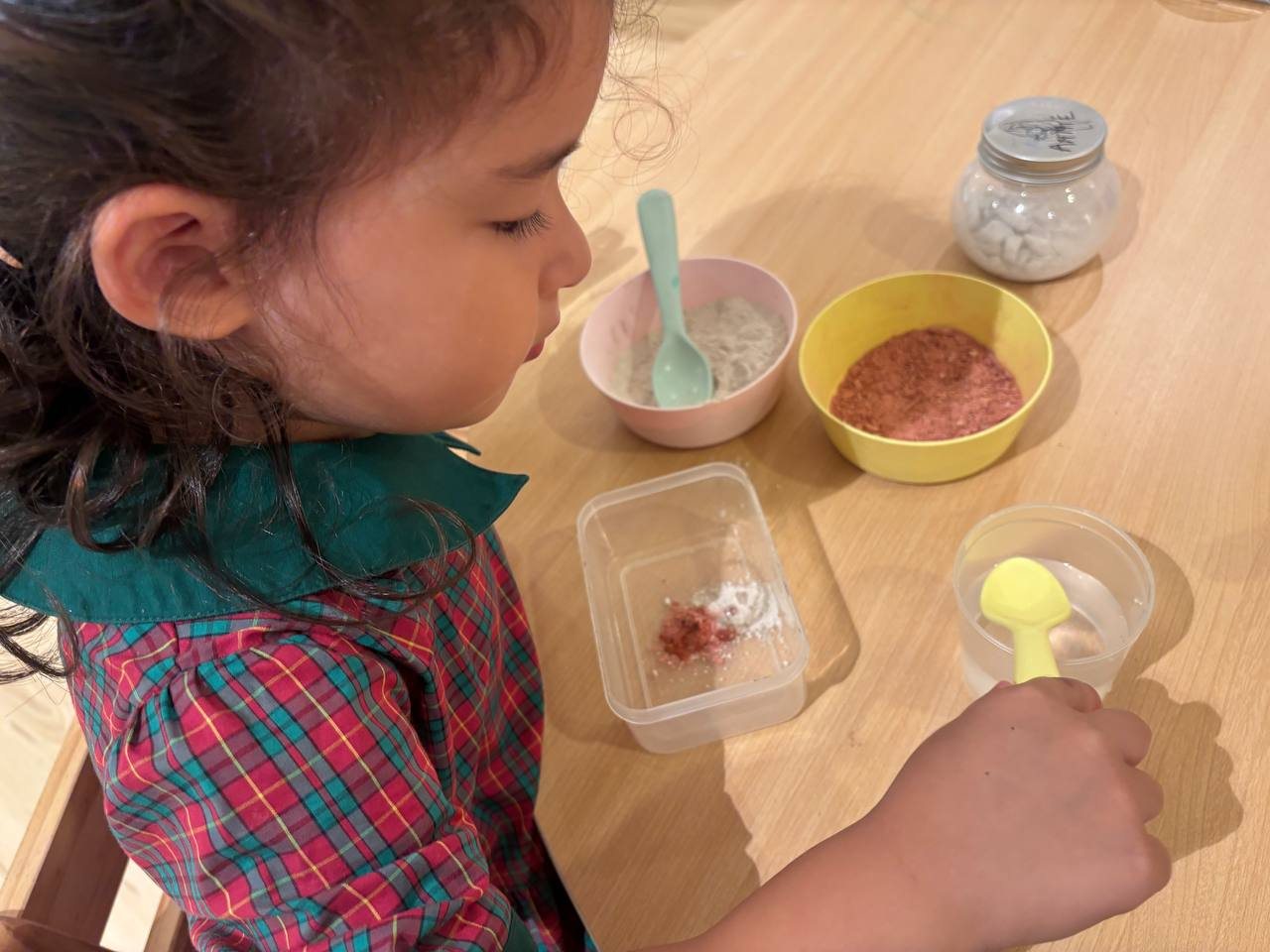 A Nursery 1 child adding water to clay powder