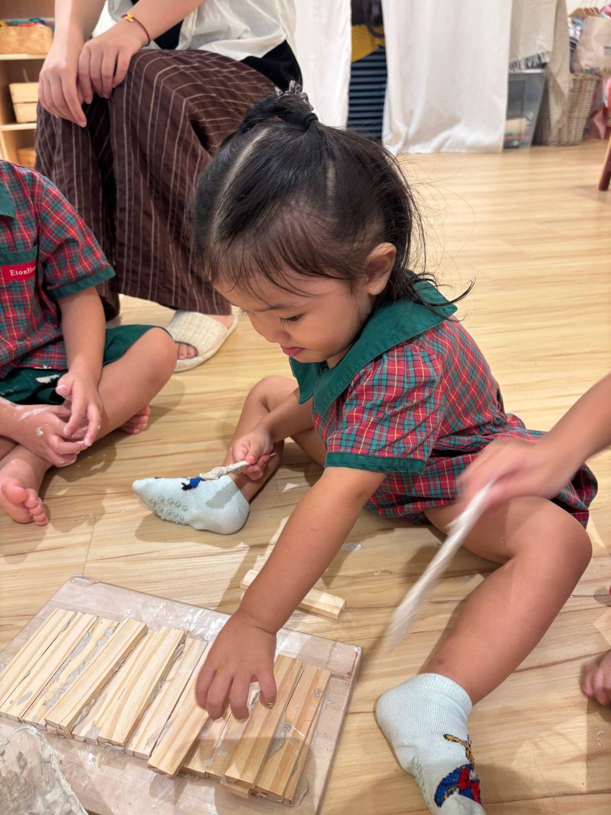 Nursery 1 children building with clay slip and wooden planks