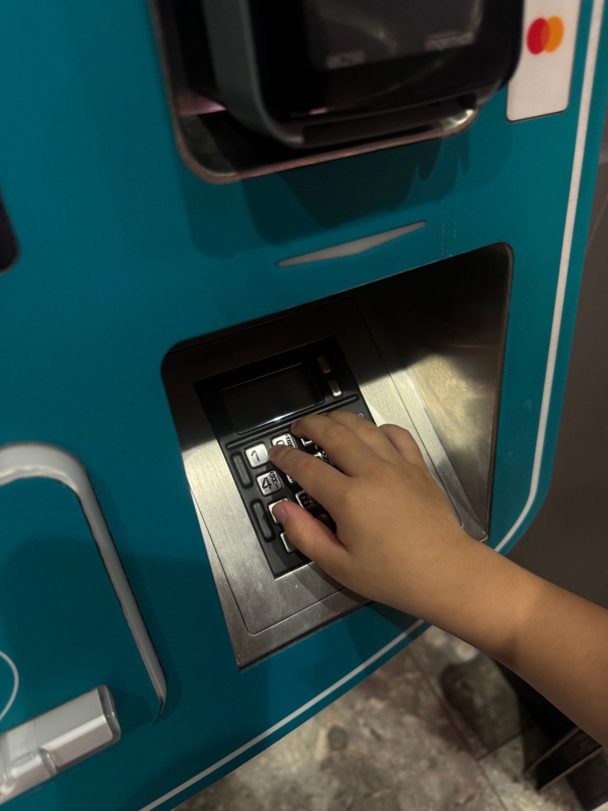 A child using a ticket machine at an MRT station