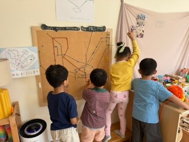 Children referring to an MRT map as they create their own