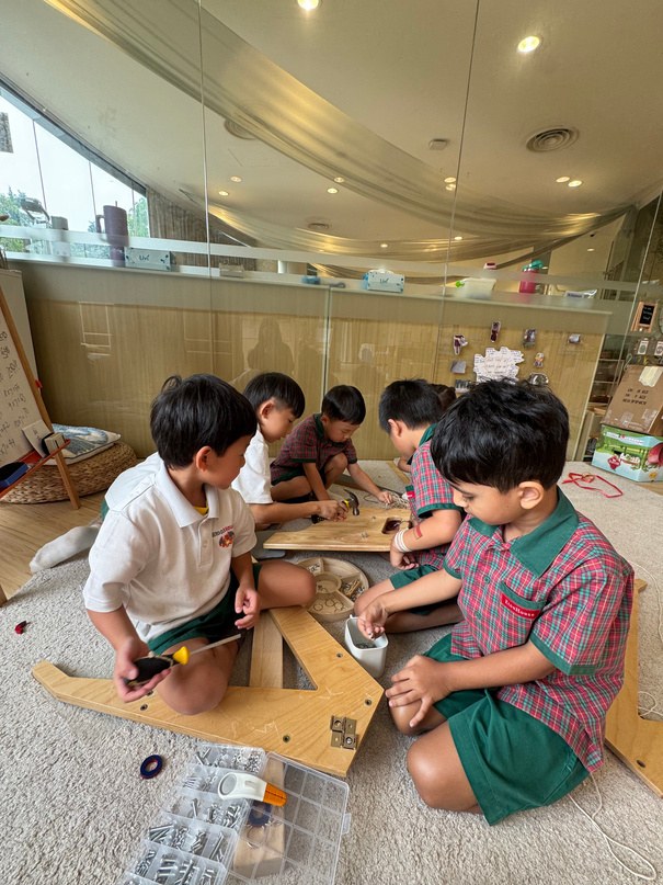 Children using loose wooden parts to create a gantry