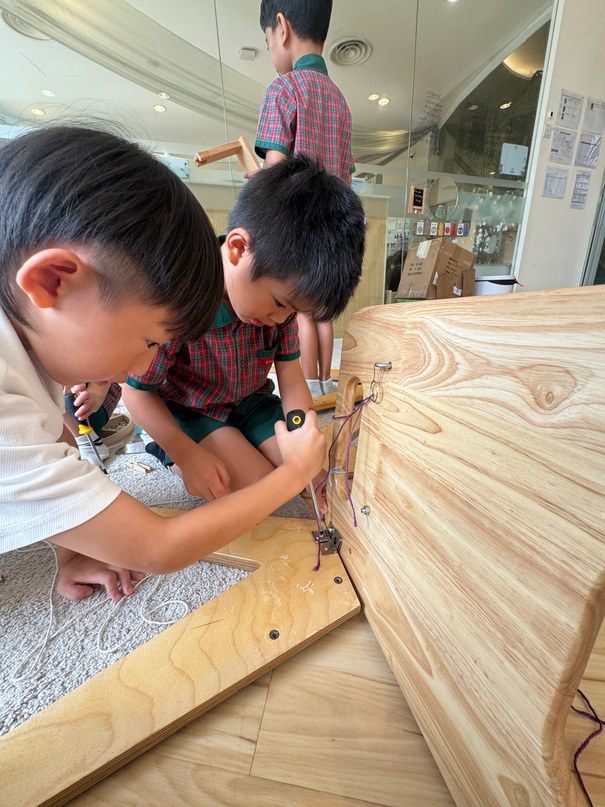 Children joining wooden parts with tools and hardware